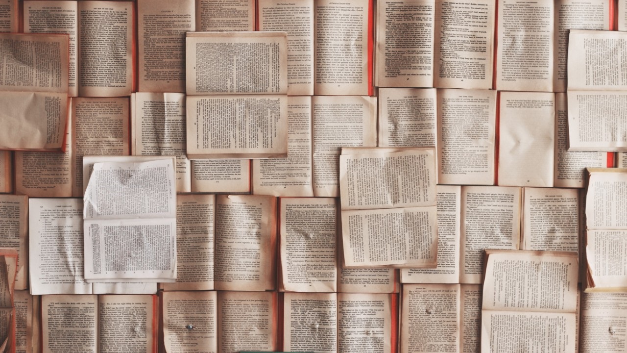 Many open books laid out with text visible